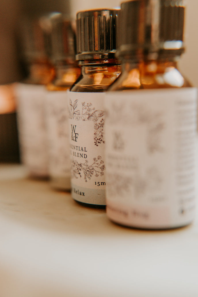 Row of essential oil bottles with labels on a blurred background