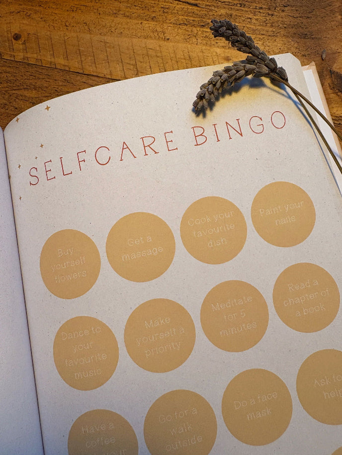 Self-care bingo card on a wooden surface with lavender.