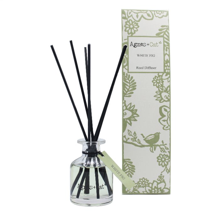 Reed diffuser with black sticks and a decorative box on a white background