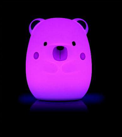 Purple bear-shaped night light on a black background