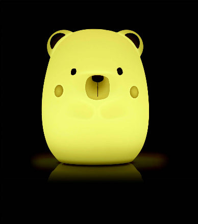 Yellow bear-shaped night light on a black background