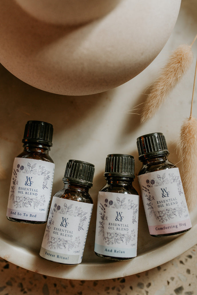 Four essential oil bottles with labels on a wooden surface