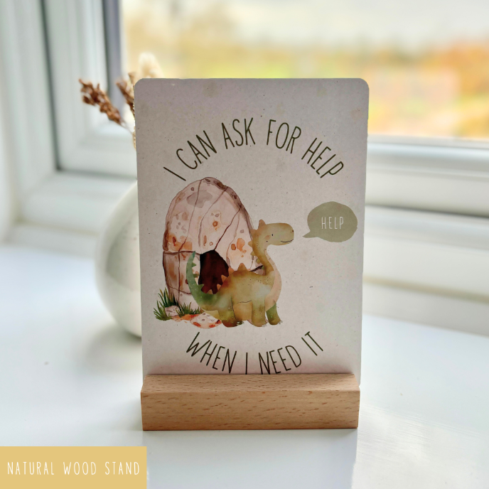 Notebook with dinosaur illustration and motivational quote on a wooden stand.