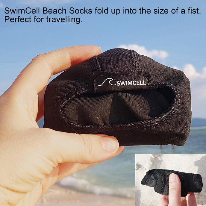 Black swim sock held by a hand with a scenic background