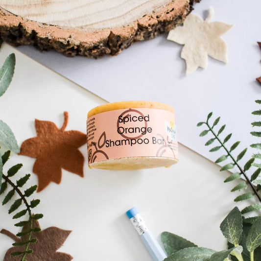 Spiced Orange Shampoo Bar on a white surface with natural elements