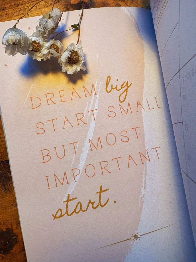Motivational quote card with flowers on a wooden surface