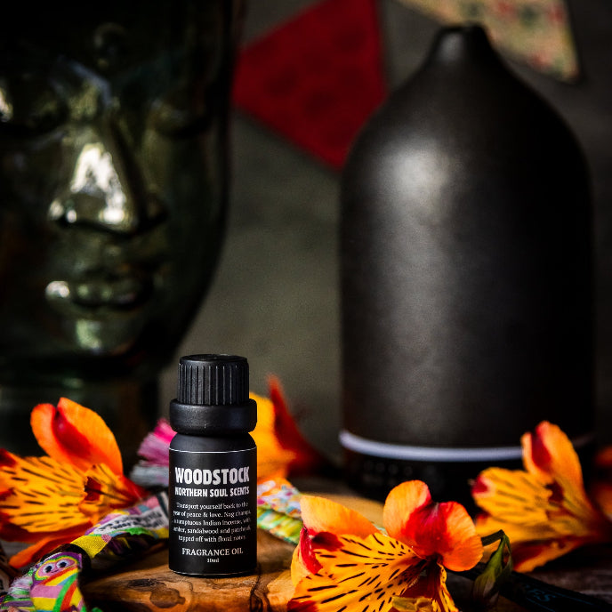 Woodstock Northern Soul Scents diffuser oil bottle with flowers and a black diffuser in the background.