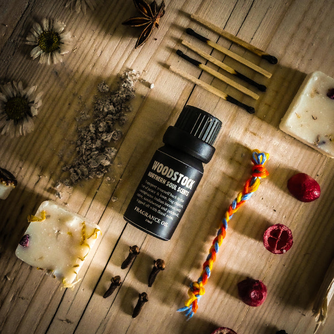 Woodstock Northern Star perfume bottle on a wooden surface with dried flowers and herbs.