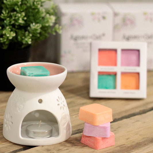 White ceramic wax warmer with colorful wax melts on a wooden surface.