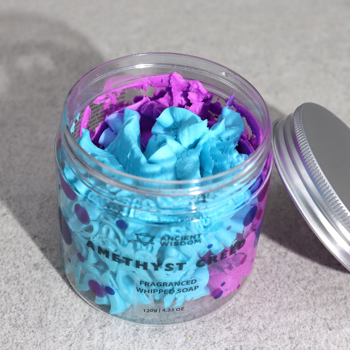 Jar of blue and purple whipped soap with a visible brand name on a gray background