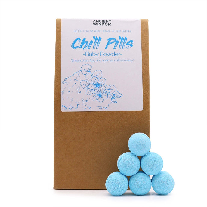 Blue bath bombs in front of a cardboard box labeled 'Chill Pills Baby Powder' on a white background