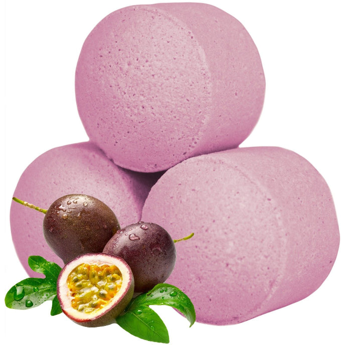 Pink bath bombs with passion fruit and leaves on a white background