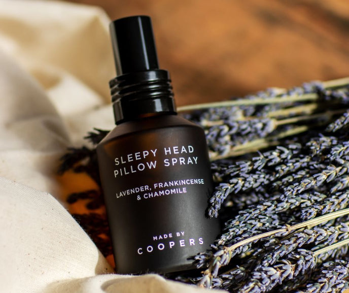 Sleepy Head Pillow Spray bottle with lavender and chamomile on a soft background