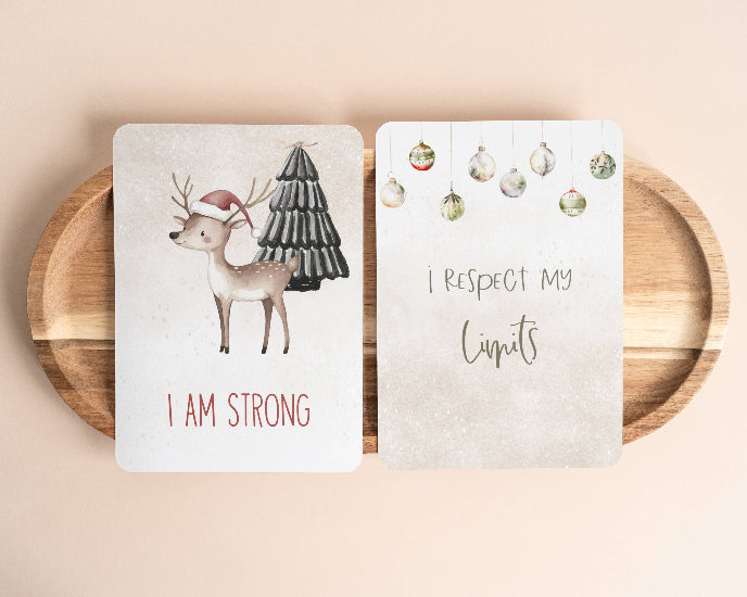 Two cards on a wooden plate with Christmas-themed designs and text.